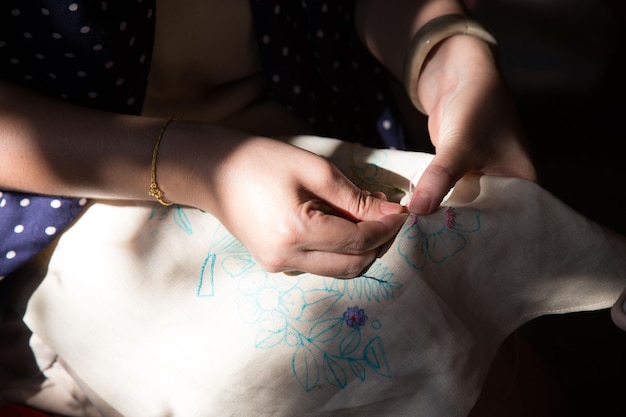 dłonie haftujące tkaninę